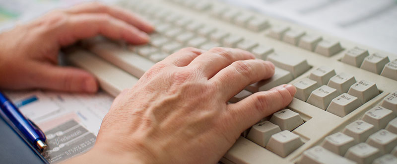 Hände schreiben auf einer Tastatur